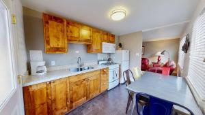 a kitchen with wooden cabinets and a table with a sink at Downtown Cozy Home Base - Purple Sage 5 in Moab