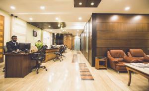 a man sitting at a desk in an office at Hotel Airport International Mumbai in Mumbai