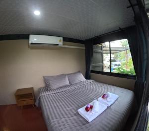 1 dormitorio con 1 cama con toallas en Little Farm Nakornnayok, 