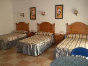 a hotel room with three beds in a room at Hostal Los Rosales in Alcaraz