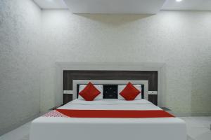 a bedroom with a large bed with red pillows at Hotel Prime Rose in Kurukshetra