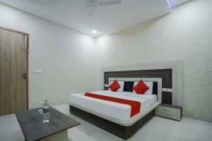 a bedroom with a large bed with red pillows at Hotel Prime Rose in Kurukshetra