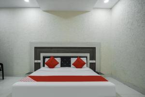 a bedroom with a large bed with red pillows at Hotel Prime Rose in Kurukshetra