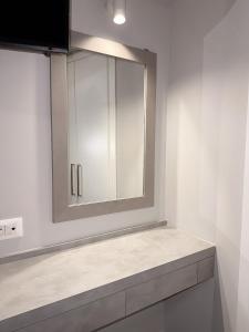 a white bathroom with a mirror and a sink at Eleni's Deluxe Apartment in Nafplio +31 photos