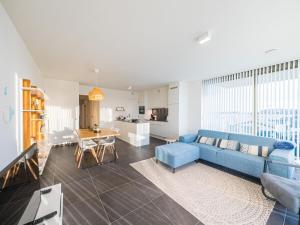 Il comprend un salon avec un canapé bleu et une cuisine. dans l'établissement Appartment 2 bedrooms with garage at Amantha 0102 on floor 1, à Middelkerke
