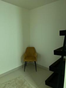 einem braunen Stuhl in einer Ecke eines Zimmers in der Unterkunft Lodges in al-Ain