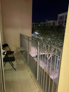einen Balkon mit einem Tisch und einem Baum in der Nacht in der Unterkunft Lodges in al-Ain