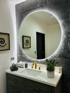 La salle de bains est pourvue d'un lavabo et d'un grand miroir. dans l'établissement NUMA Wine Suites, à Ensenada
