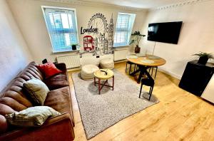 uma sala de estar com um sofá e uma mesa em Flat 6 Stay In Aldgate em Londres
