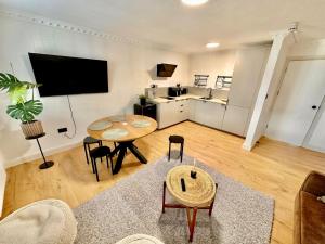 uma sala de estar com uma mesa e uma cozinha em Flat 6 Stay In Aldgate em Londres