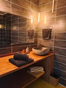 ein Badezimmer mit einem Waschbecken auf einer Holztheke in der Unterkunft Villa Tourmaline in Le Lorrain