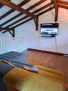 - un salon avec un canapé et une télévision murale dans l'établissement Villa Tourmaline, à Le Lorrain