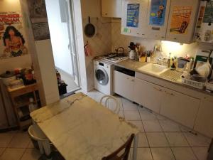 a kitchen with a table and a stove and a sink at Chambre & table d'hôte à 5 min de la gare Matabiau in Toulouse
