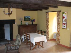 ein Esszimmer mit einem weißen Tisch und Stühlen in der Unterkunft Tavaud in Dournazac