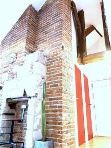 un mur de briques avec un cactus devant lui dans l'établissement Le Tripode-Hypercentre au calme et atypique, à Nantes