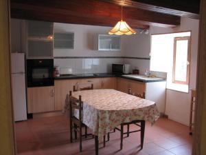 eine Küche mit einem Tisch mit einer Tischdecke in der Unterkunft Tavaud in Dournazac + 2 Fotos