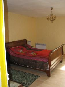ein Schlafzimmer mit einem Bett und einem Kronleuchter in der Unterkunft Tavaud in Dournazac