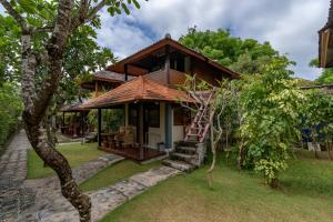 a house with a staircase leading up to it at Ketut Losmen Bungalows Lembongan in Nusa Lembongan