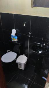 Baño negro con aseo y lavamanos en Casa de Praia Mosqueiro - São Francisco, en Belém