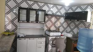 una pequeña cocina con paredes de baldosas blancas y negras. en Casa de Praia Mosqueiro - São Francisco, en Belém