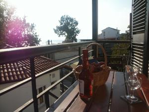 a bottle of wine and a basket of fruit on a balcony at Katia Hotel in Afissos