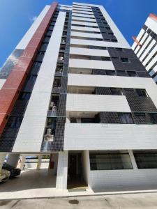 um edifício de apartamentos alto com pessoas na varanda em Cobertura Duplex Beira Mar 3 quartos em Maceió