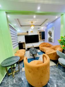 The Jumeirah Guest Home في ياوندي: غرفة معيشة مع كنب وتلفزيون بشاشة مسطحة