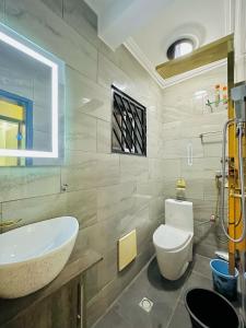 uma casa de banho com um lavatório branco e um WC. em The Jumeirah Guest Home em Iaundé