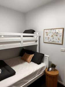 a bedroom with a bunk bed and a table at Bundalong Villas in Bundalong
