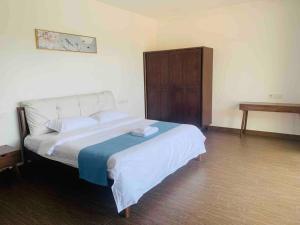 ein Schlafzimmer mit einem großen Bett und einem Tisch in der Unterkunft 【森林城市高尔夫】度假式双层别墅民宿 in Gelang Patah