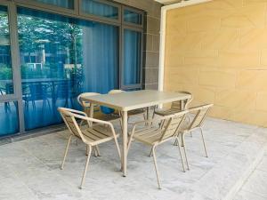 ein Tisch und Stühle auf einer Terrasse in der Unterkunft 【森林城市高尔夫】度假式双层别墅民宿 in Gelang Patah