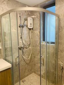 a shower in a bathroom with a glass door at 【森林城市高尔夫】度假式双层别墅民宿 in Gelang Patah