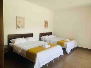 two beds in a room with white walls at 【森林城市高尔夫】度假式双层别墅民宿 in Gelang Patah