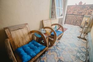 Habitación con 2 sillas y mesa con asiento azul en Samblung Mas House, en Denpasar