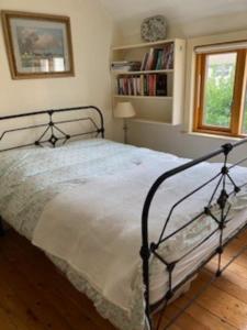 1 dormitorio con cama de marco negro y ventana en Serene 2BD Home wGarden Newtown Little Dublin! en Rathgar