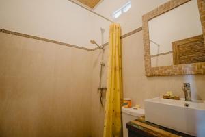 a bathroom with a sink and a mirror at Samblung Mas House in Denpasar