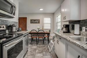 a kitchen with a sink and a table at Chic Home with Huge Grassy Yard 7 mins to Arrowhead Stadium in Independence