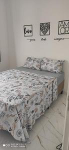 łóżko z kołdrą i poduszkami w obiekcie Apartamento Residencial HM enseada w mieście Guarujá