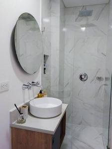 La salle de bains blanche est pourvue d'un lavabo et d'un miroir. dans l'établissement Maravilloso loft en el centro de Chapinero 319, à Bogotá