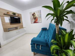 un sofá azul en una sala de estar con una planta en Apartamento con excelente vista, en Cúcuta