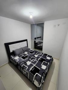 a bedroom with a bed with a black and white quilt at Apartamento con excelente vista in Cúcuta