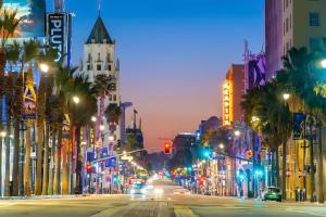 a city street at night with traffic lights and palm trees at Los Angeles Premium City Suites with Free Parking in Los Angeles