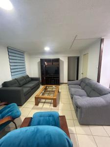 Sala de estar con 2 sofás y mesa en DEPARTAMENTO DICHATO, en Tomé