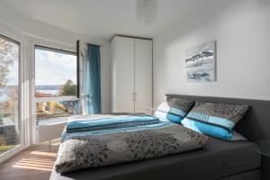 a bedroom with a bed and a large window at Mainaublick in Uhldingen-Mühlhofen