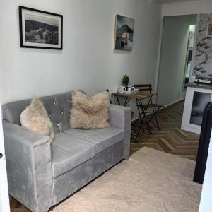 a living room with a gray couch with fur pillows at Aparta estudio en santiago #1 in Santiago de los Caballeros