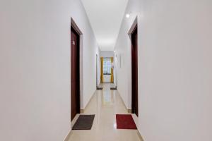 un corridoio con pareti bianche, porte e tappeti neri di Collection O Prashant Stays a Trippapur