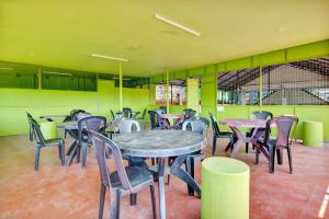 una sala da pranzo con tavoli, sedie e pareti verdi di Collection O Prashant Stays a Trippapur
