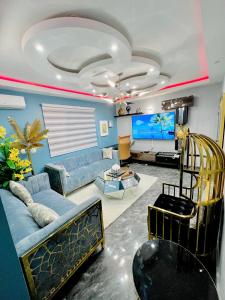 a living room with a couch and a flat screen tv at The Jumeirah Guest Home in Yaoundé