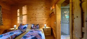 um quarto com uma cama num chalé de madeira em Ferienwohnungen Ramslerhof em Ruhpolding