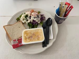 un plato de comida con una ensalada y un sándwich en KRABI MORE HOTEL, en Klong Muang Beach